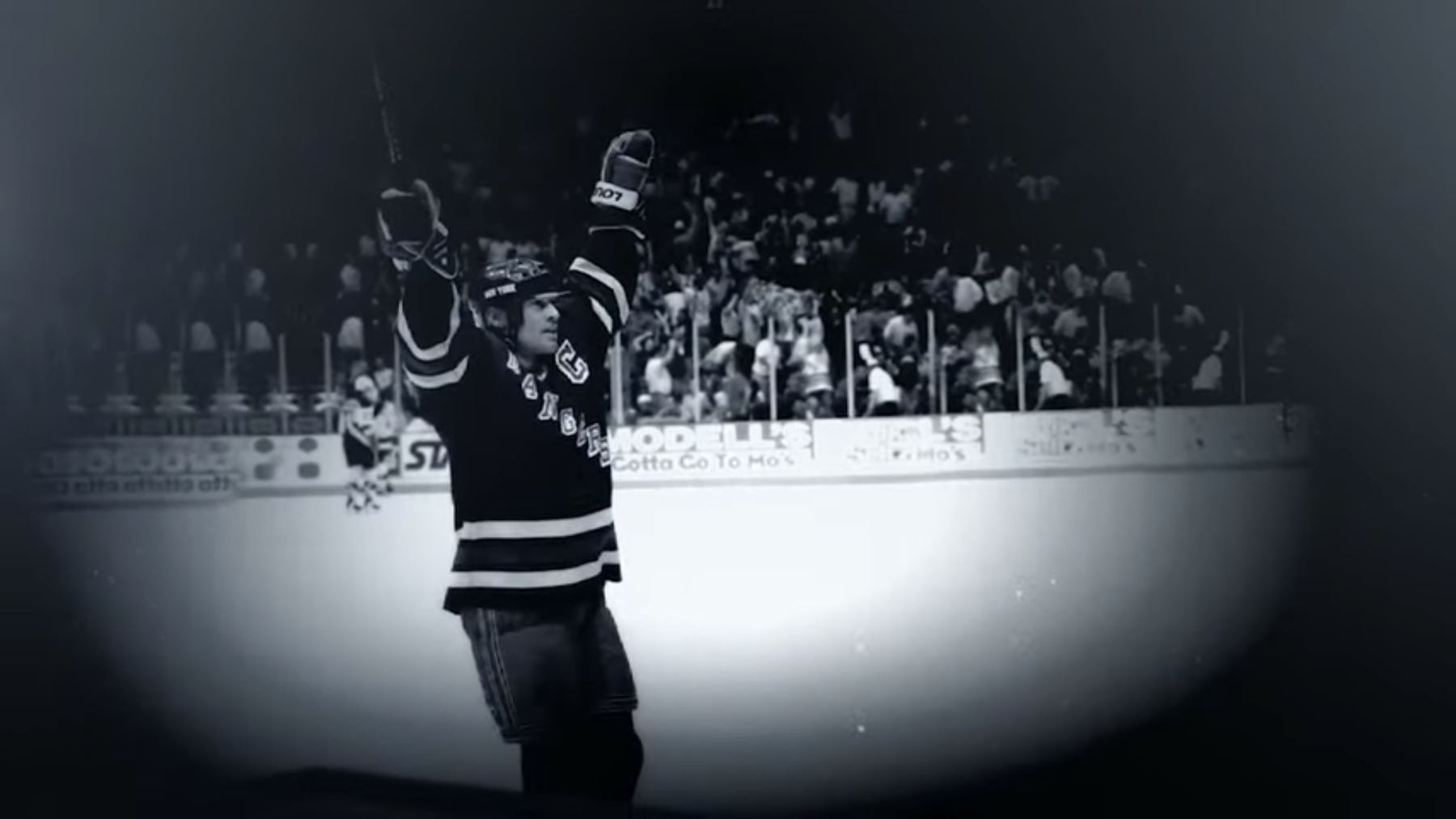 Mark Messier in a Rangers jersey, both arms raised in celebration