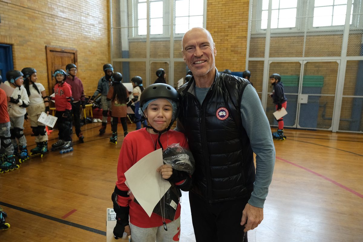 Mark Messier with an Inline-2-Ice student holding a certificate in the PS 86 gym