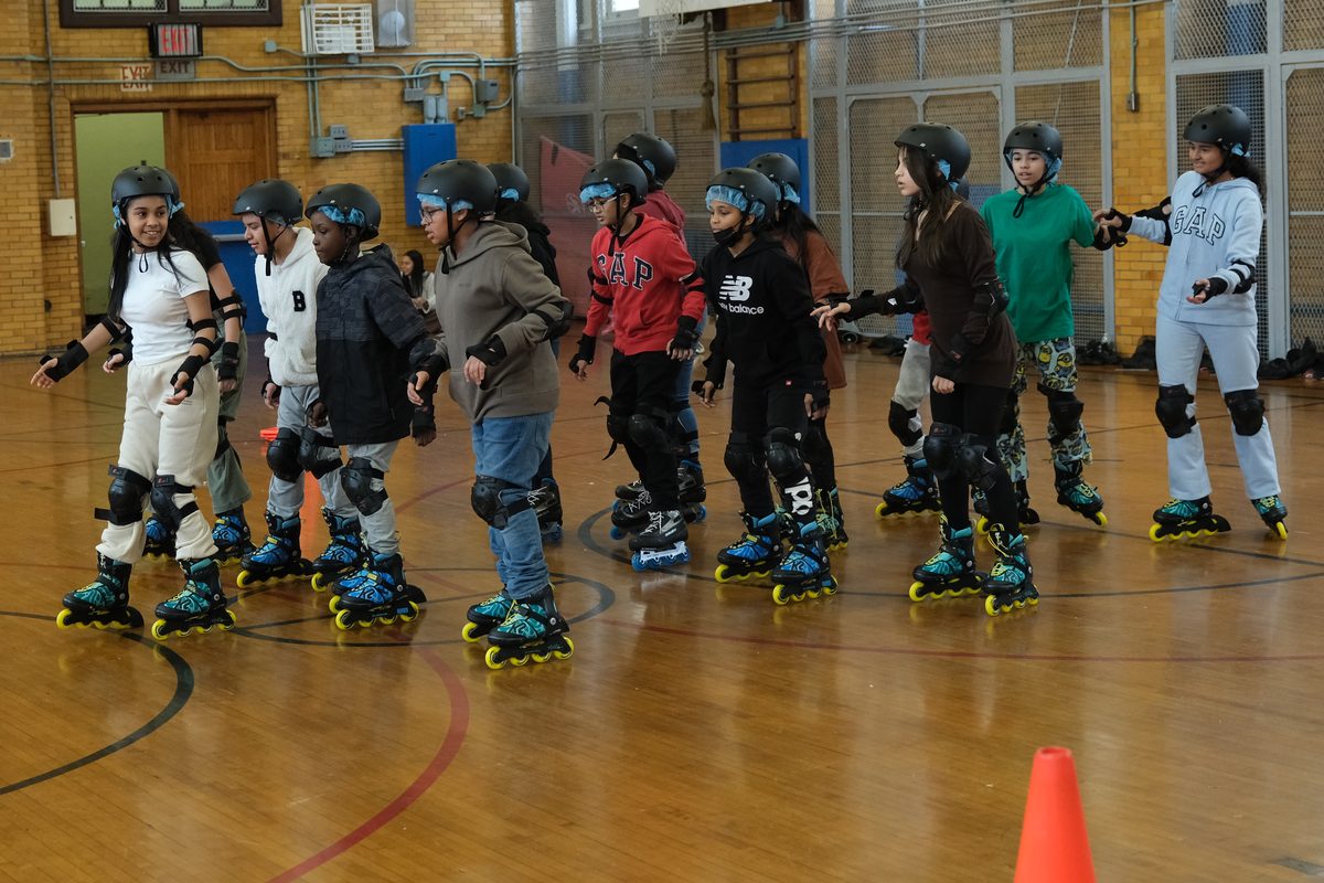A line of Inline-2-Ice students on inline skates in the school gym
